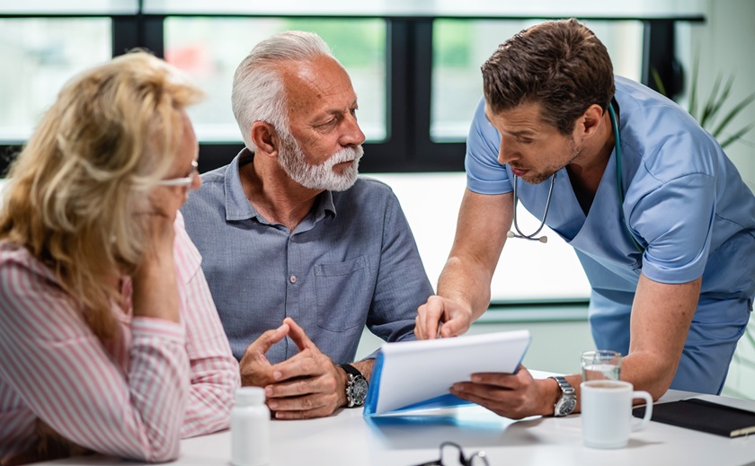 ernstige-arts-gesprek-met-senior-koppel-hun-medische-documenten-tijdens-afspraak-bij-kliniek.jpg