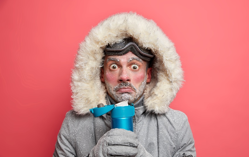 foto-van-geschokt-beschaamd-man-beeft-van-kou-besteedt-veel-tijd-buiten-tijdens-ijzig-weer-dranken-hete-thee-houdt-thermosfles-draagt-outfit-voor-wintersport.jpg